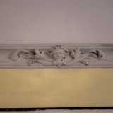 ...con volti allegorici e ornamenti a foglie